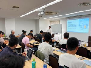 「集客前にやっておきたい治療院改善講座」タイトルスライドと会場（治療院経営ラボ月例ワーク 2026年7月）