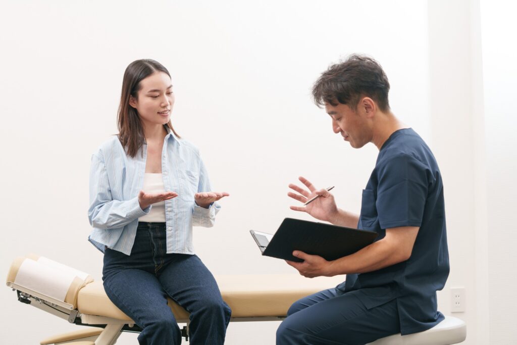 問診で患者さんと施術者が身ぶりを交えて話している様子