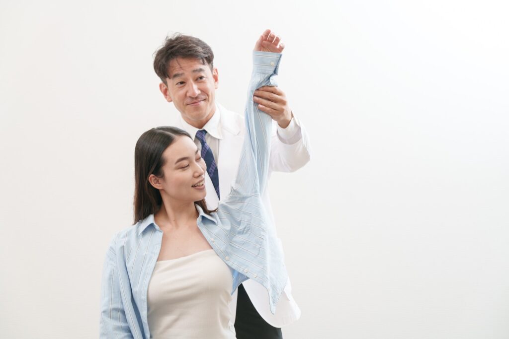 施術者が患者さんの腕を持ち上げて体の動きを確かめている様子