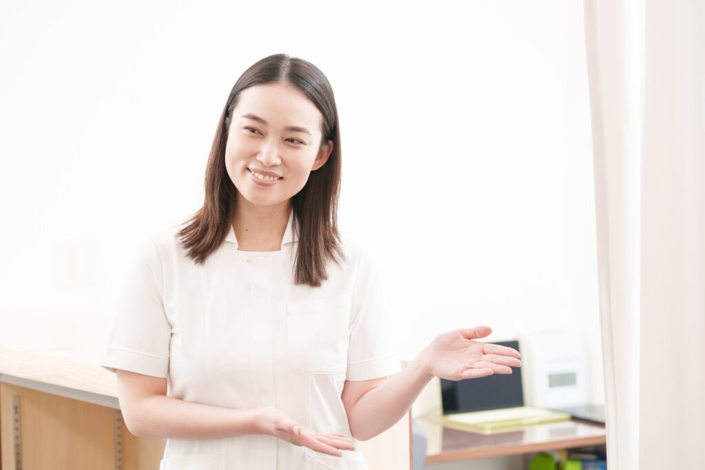 治療院の受付で、スタッフが笑顔で案内している様子